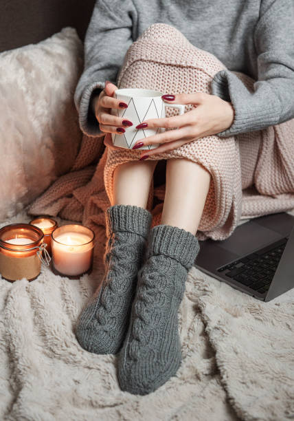 istock Cozy home, woman covered with warm blanket, drinks coffee. 1431913631