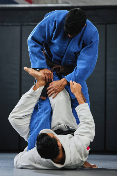 istock Karate, fitness and exercise of a student training with a coach and learning in a contact sport. Man with personal trainer in martial arts sports fight for safety, wellness and health in a gym. 1431913708