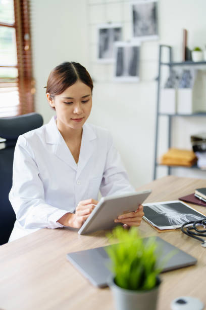 istock An Asian female doctor is using a tablet computer to analyze patient symptoms before treatment 1431914041