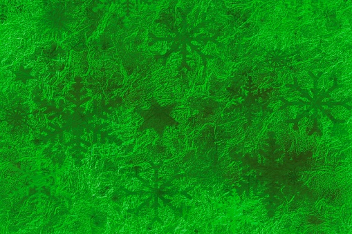 Abstract green glowing holiday background with star shapes and snowflakes.