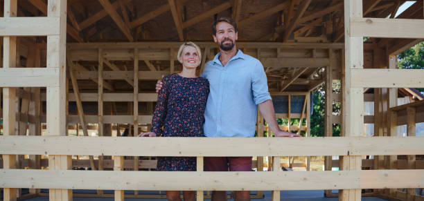 Two parents with their daughter in front of the new house their daughter bought and became home owner