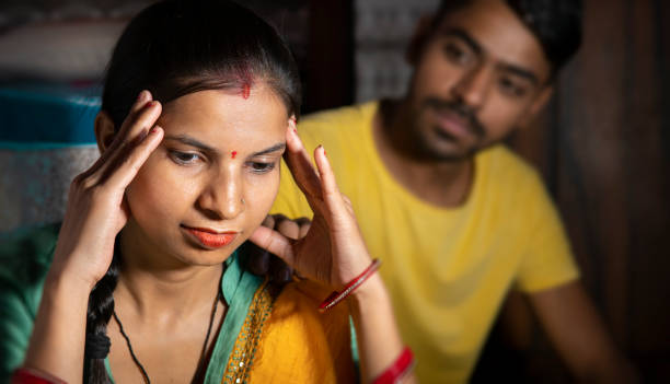 istock Indian man consoling his wife who is thinking about problems by holding her head at home. 1431917077