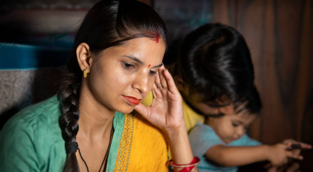triste, serena donna indiana sposata tenendo la testa e pensando profondamente a casa. - domestic life family heterosexual couple young family foto e immagini stock