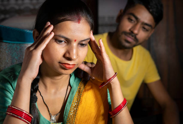istock Indian man consoling his wife who is thinking about problems by holding her head at home. 1431917099