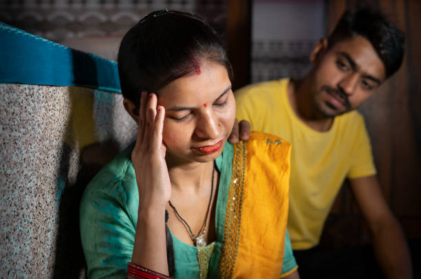 indischer mann tröstet seine frau, die über probleme nachdenkt, indem er ihren kopf zu hause hält. - ehefrau stock-fotos und bilder