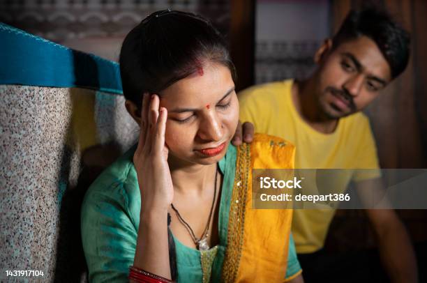 Indian Man Consoling His Wife Who Is Thinking About Problems By Holding Her Head At Home Stock Photo - Download Image Now