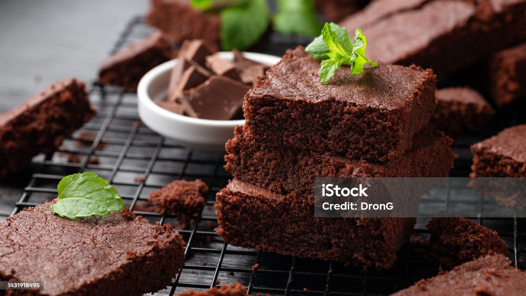 Chocolate brownies garnished with mint on cooling rack. Sweet food Chocolate brownies garnished with mint on cooling rack. Sweet food. Brownie Stock Photo