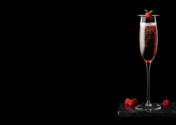 黒い背景に黒い大理石のボードに新鮮なベリーとミントの葉とスティックにラズベリーとピンクのバラのシャンパンのエレガントなガラス。テキスト用のスペース - champagne celebration glass black ストックフォトと画像