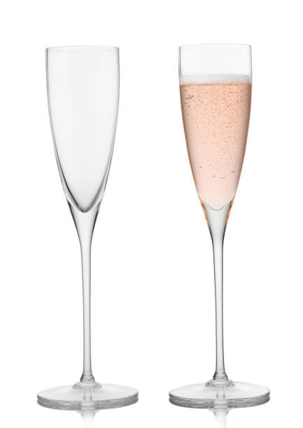 istock Empty and full pink rose champagne crystal glasses on white background. 1431923364