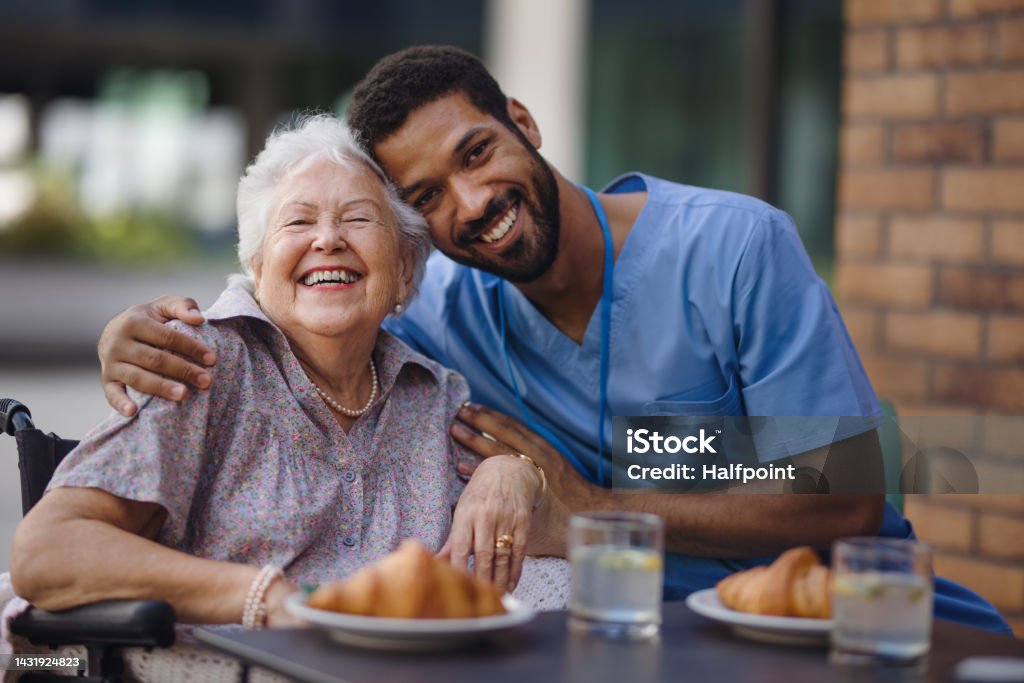Caregiver having breakfast with his client at cafe. Caregiver having breakfast with his client at a cafe. Senior Adult Stock Photo