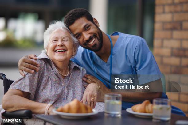 Caregiver Having Breakfast With His Client At Cafe Stock Photo - Download Image Now