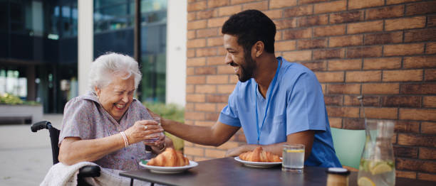 istock Caregiver having breakfast with his client at cafe. 1431924876