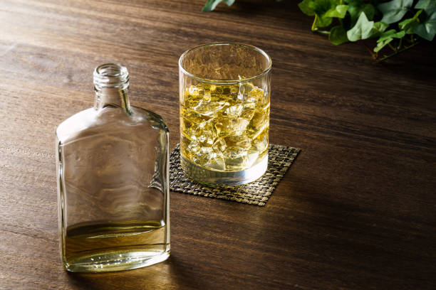 istock Whiskey in a glass with ice on a wooden table 1431926616