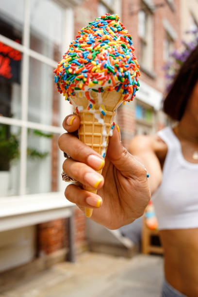 istock Woman holding  Ice Cream Cone with Rainbow Sprinkles 1431930115