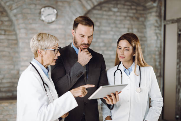 istock Businessman and doctors talking while working on touchpad in the office 1431934566