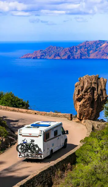 Photo of Corsica isalnd senery, road travel by camper. Famous national park Calanques della Piana, with stunning red rocks