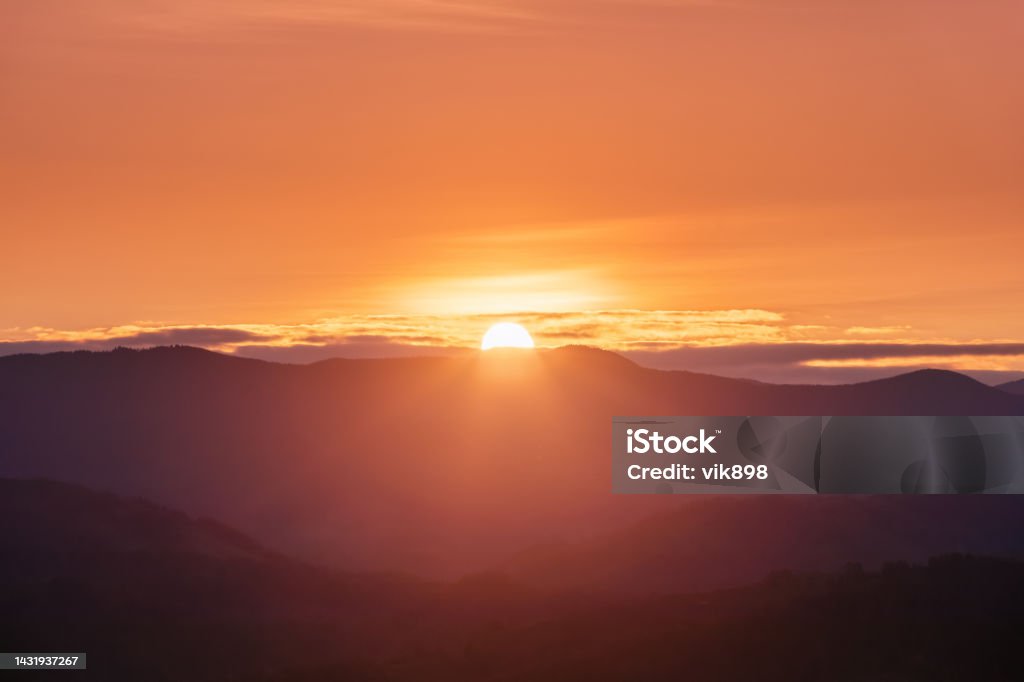 Beautiful sunrise. Sun rays enlighten the meadow with trees. Spring morning. Landscape with high mountains. Panoramic view. Natural scenery. Wallpaper background. Touristic place Carpathian park. Sunrise - Dawn Stock Photo