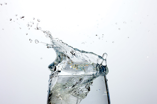 Two symbolic human hearts in a glass container with water against the background of the sky