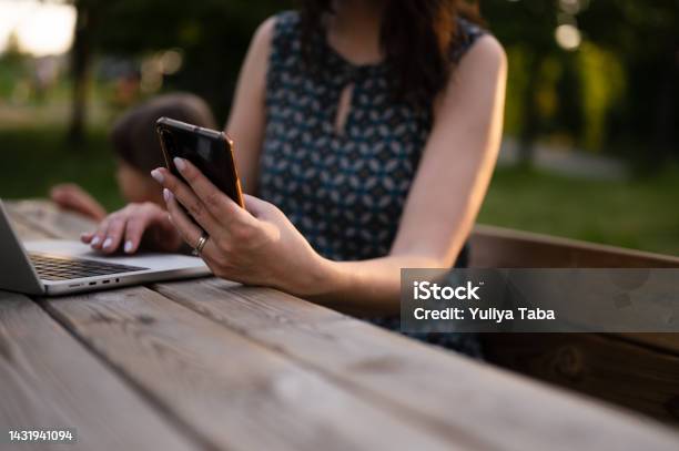 Beautiful Business Woman Working On A Laptop Sitting On The Bench In A Park In The Evening Stock Photo - Download Image Now