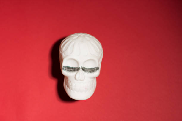 istock Cheerful Human skull with eyelashes on a red background. Halloween decorations. Halloween concept. Flat lay, top view, copy space. 1431943345