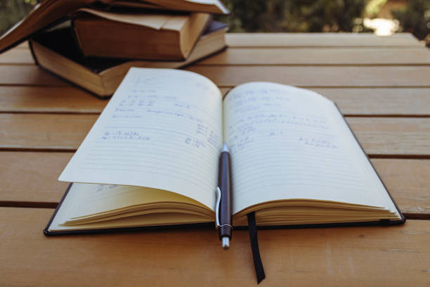 istock Notebook with pen and pile of books on the table 1431945077