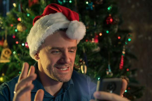 istock Happy man calling friends for Christmas using smartphone 1431948184