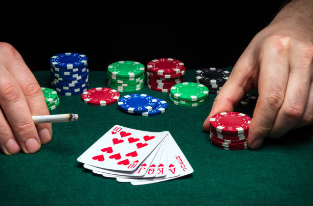 Poker cards with combination of two pairs in play. Hands of a player close up and chips on a green table in a poker club Hands of a gambler closeup and chips on green table in a poker club. A player places a bet on winning poker dibs stock pictures, royalty-free photos & images