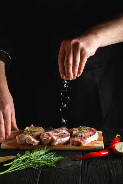 istock The chef sprinkles the meat with salt. Preparing meat before baking. Working environment in the kitchen of restaurant or cafe 1431957422
