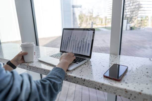 istock One hand to operate the laptop to view the chart 1431962296