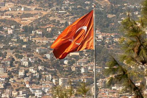 Alanya, Turkey - September 17, 2022: Turkish flag on the background of the city