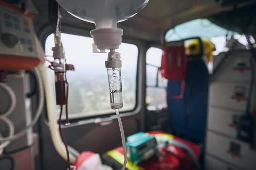 Selective focus on infusion on board helicoter of emergency medical service. Themes rescue, urgency and health care.