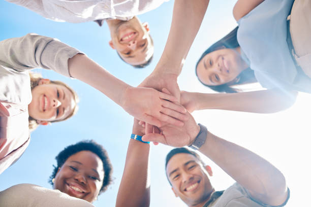 istock Group of friends hands stacked in success and unity from below for teamwork, collaboration and outdoors bonding. Diverse team showing support, togetherness and community, united for a common goal. 1431968600
