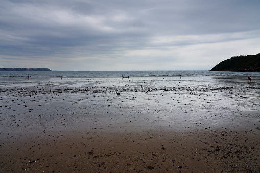 Only a small number of people on Oxwich beach on a cold and cloudy afternoon.