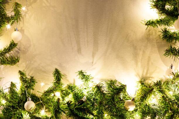 istock Christmas tree branches decorated with black and white balls and light garland on a white background 1431970368