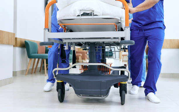 medical staff pushing patient on medical gurney at emergency department, bottom view. hospital emergency and healthcare workers - stretcher imagens e fotografias de stock