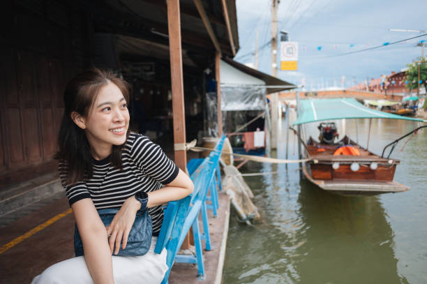 Young travel trip tourist having fun at floating amphawa street market riverside at thailand
