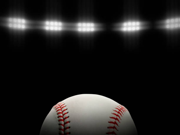 istock Baseball ball on a black background under stadium lights 1431974150