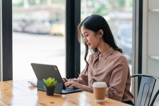 istock Young Asian business woman sitting think about work using a tablet at the office. 1431974665