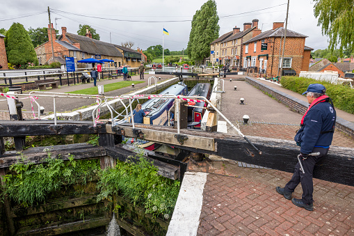 Northamptonshire, UK - May 25, 2022. Lock keeper, a female volunteer operates the lock at Stoke Bruerne, a historic village on the Grand Union Canal