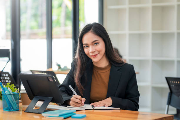 istock Young Asian business woman sitting think about work using a tablet at the office. 1431975562