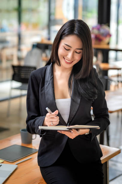 istock Young Asian business woman sitting think about work using a tablet at the office. 1431975585
