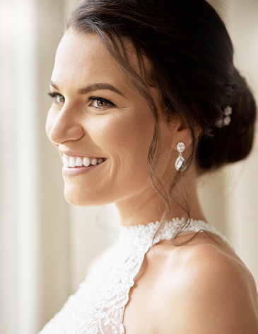 Beauty, makeup and face of a bride with happiness for her wedding event or ceremony. Smile of a woman happy for her marriage and wearing jewelry with elegant hairstyle and fashion or luxury cosmetics