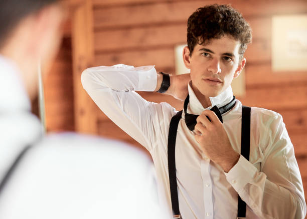 istock Wedding, groom and tradition with a man getting ready on his marriage day for a celebration event. Fashion, love and mirror with a young male preparing to be married while standing alone in a room 1431978837