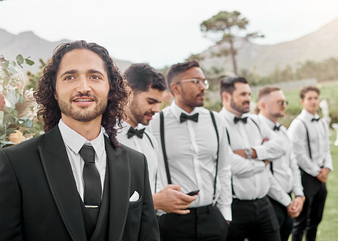 Wedding, groom and marriage with a man and his groomsmen standing outside for a ceremony, tradition or celebration event. Happy, married or occasion with a male bridegroom waiting at an outdoor venue