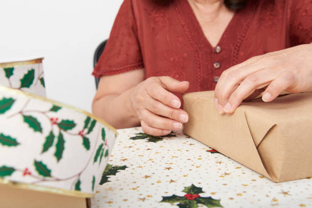 istock Unrecognizable mature woman wrapping Christmas gifts. 1431982987