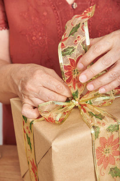 istock Woman making a bow with a decorative ribbon for decorating a Christmas gift. 1431984461