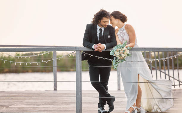 istock Relax, wedding and bride with groom on dock for romantic moment together on commitment day. Elegant, stylish and formal bridal couple enjoy peaceful lake rest break at marriage celebration. 1431988001