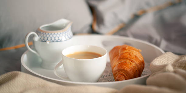 istock Breakfast on a tray in bed. Coffee, croissant and milk. Romantic concept 1431988570