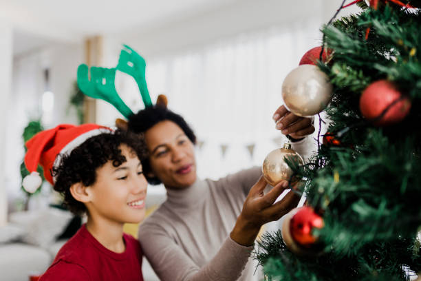 istock Boy decorating Christmas tree with his mother 1431991386