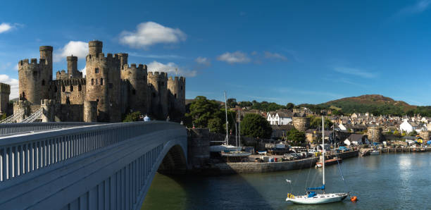 panorama view of the Conwy Castle and bridge with the walled town and harbor behind Conwy, United Kingdom - 27 August, 2022: panorama view of the Conwy Castle and bridge with the walled town and harbor behind conwy castle stock pictures, royalty-free photos & images